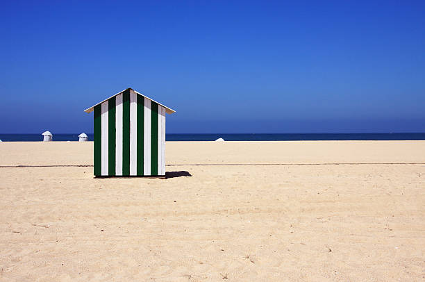 Candy-striped beach-hut, deserted beach stock photo