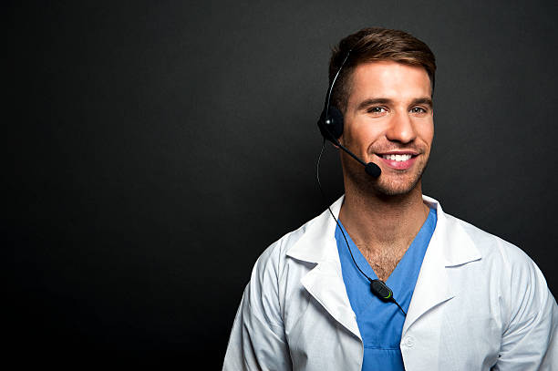 Portrait of confident young medical doctor on dark background stock photo