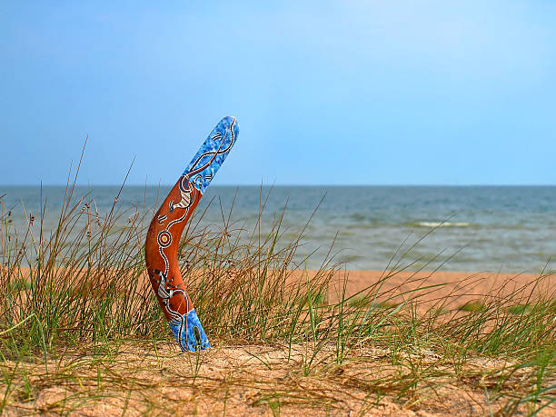 farbe bumerang auf überwachsen sandstrand. - australia boomerang aboriginal aborigine stock-fotos und bilder