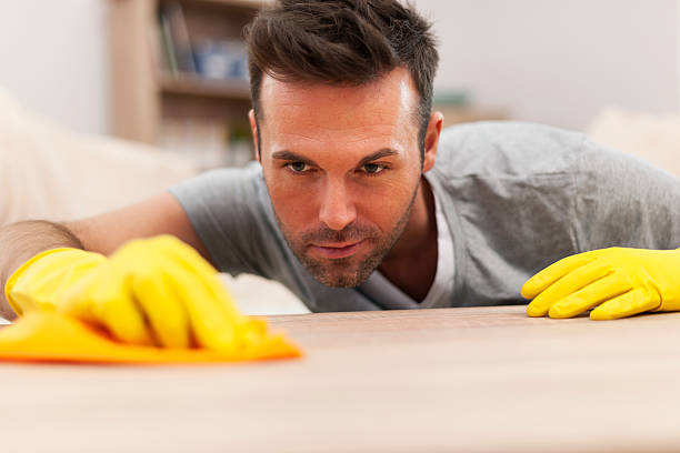 istock Handsome man cleaning stains off the table 460578537