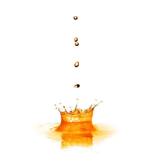 istock drop falling into orange water with splash isolated on white 460582091