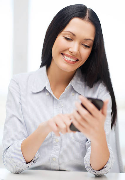 istock Business woman or student smiling while using a smartphone 460587585