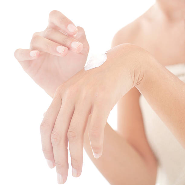 Young woman applies cream on her hands. Selective focus stock photo