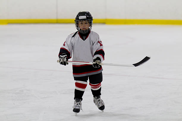 istock Little boy playing ice hockey 460592501