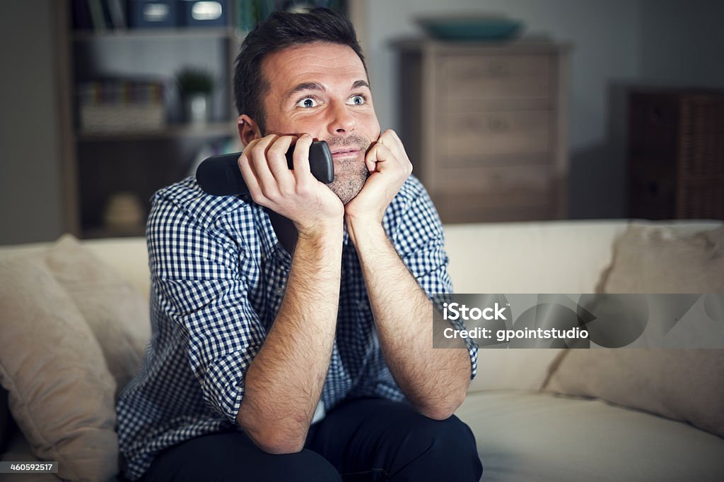 Sonriente hombre mirando interesante película - Foto de stock de Mirar la televisión libre de derechos