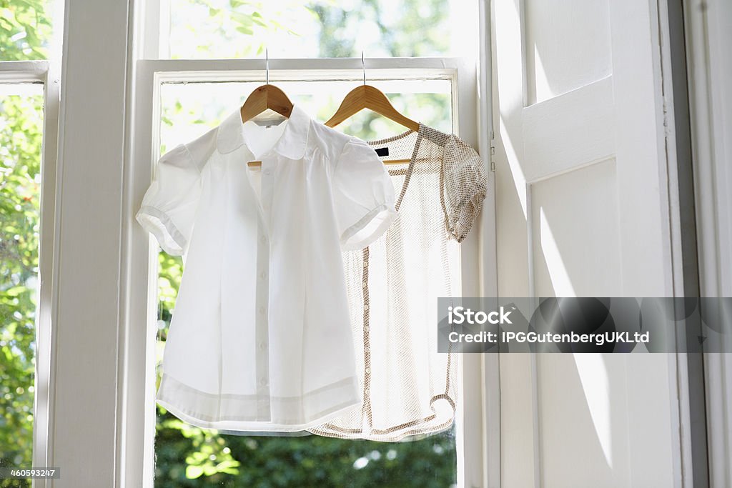 Blouses On Hangers At Home Blouses on hangers at domestic window Absence Stock Photo