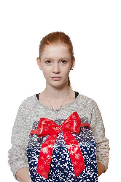 Young red haired Girl presenting a gift stock photo