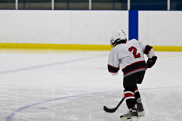 istock Young child skating and playing ice hockey 460632159