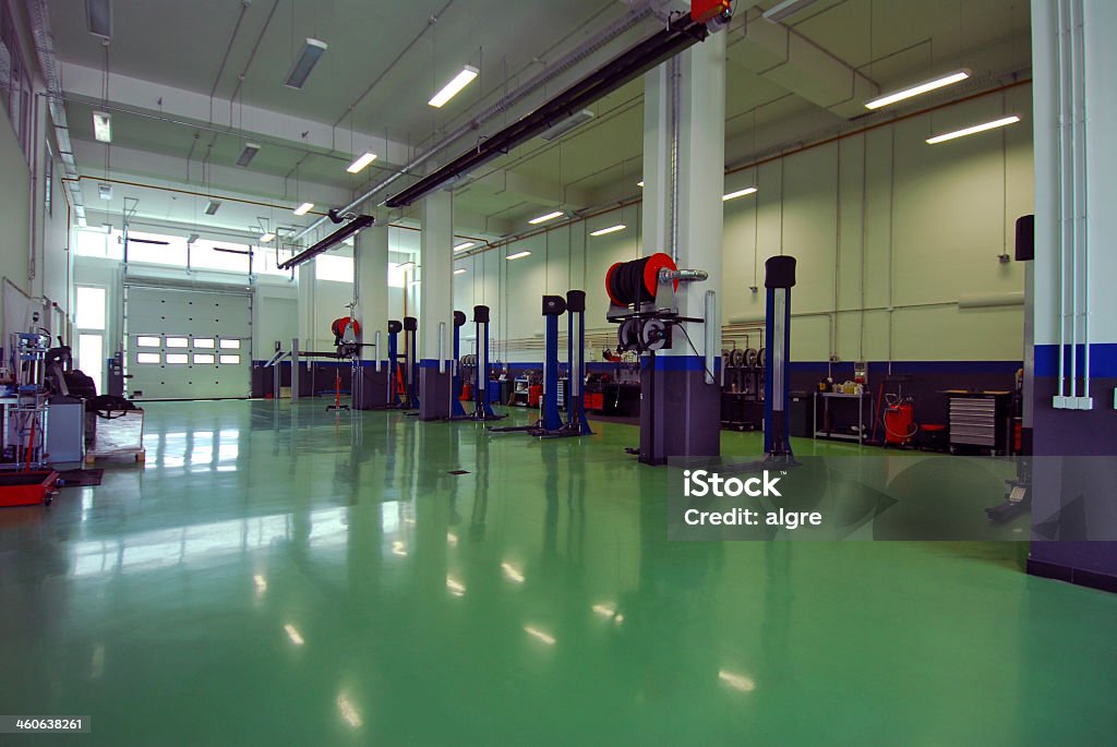 An empty repairs garage with green floor brand new car servicing prepared to work Auto Repair Shop Stock Photo