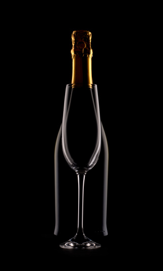 Silhouette of a Champagne bottle and flute. The bottle is behind the flute.