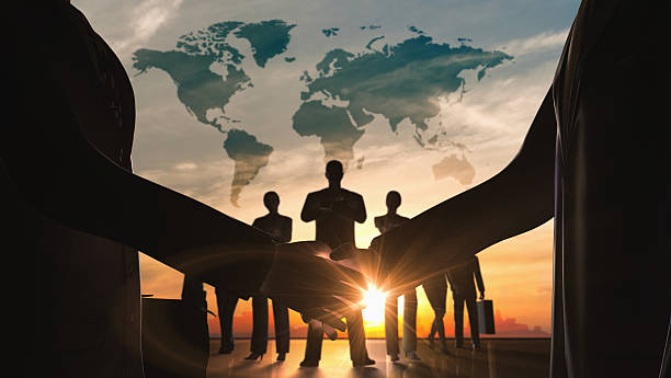 istock World business shake hand with teamwork silhouettes 460651819