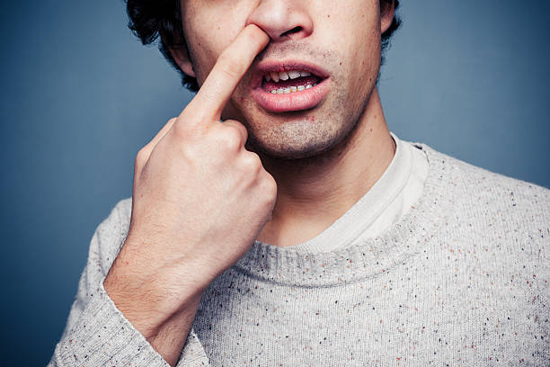 hombre joven es utilizar su nariz - picking nose fotografías e imágenes de stock