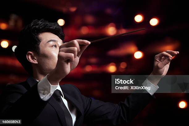 Junge Dirigent Mit Baton Hoch In Einem Performance Stockfoto und mehr Bilder von Dirigent - Dirigent, Konzerthaus, Seitenansicht