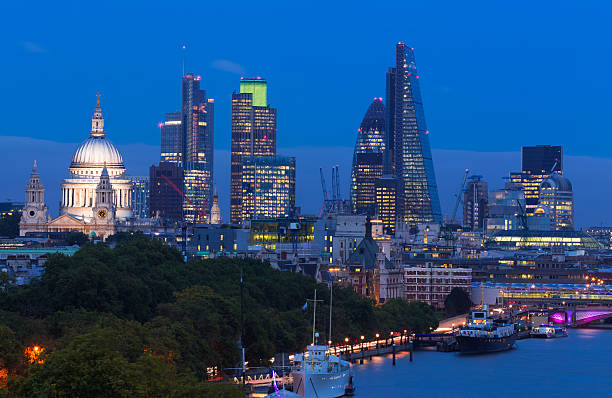 London City Skyline Night View of St Paul's River Thames Elevated view of The City of London and River Thames at dusk. The skyline features St Paul's Cathedral, Heron Tower, Tower 42, The Gherkin and Cheese Grater skyscrapers that make up London's financial district, England, UK gherkin london night stock pictures, royalty-free photos & images