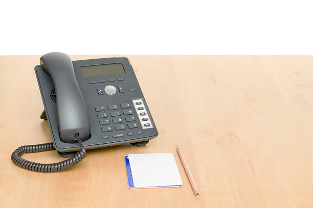 phone on desk with notepad. wooden background stock photo