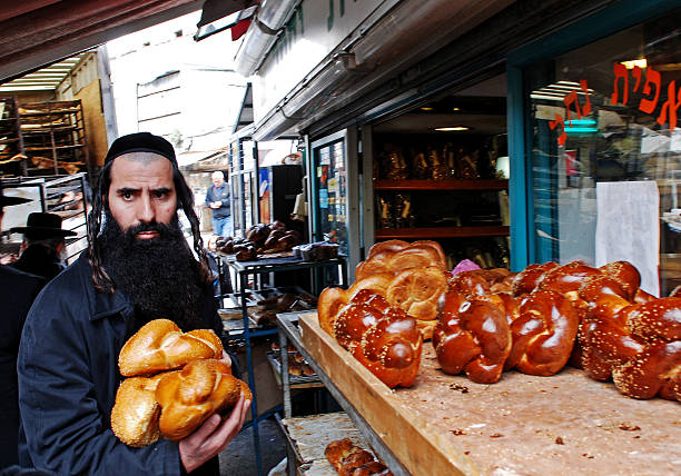 Bread for shabbat. Jerusalem, Israel- January 29, 2007: An Ultra Orthodox Jewish man buying bread at a Kosher Bakery in the quarter of Mea Shearim in Jerusalem. orthodox judaism photos stock pictures, royalty-free photos & images