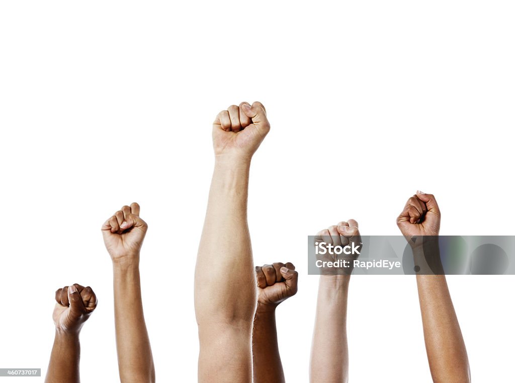 Together we stand! Many clenched fists punch air energetically Many mixed clenched fists punch up into the air energetically in unanimous approval or rebellion. Isolated on white. Punching The Air Stock Photo