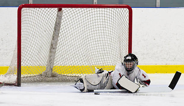 istock Child hockey goalie making a save 460743339