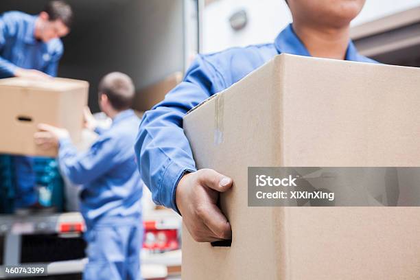 Movers Unloading A Moving Van Stock Photo - Download Image Now - Relocation, Moving Van, Moving House