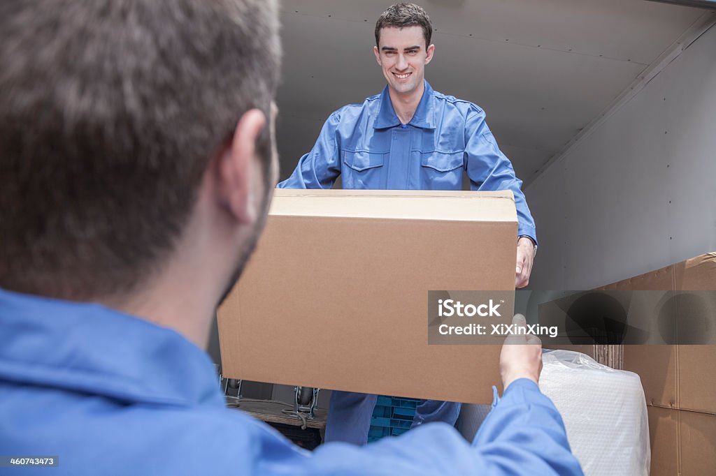 Two Man Carry Box Two Men In Overalls Carrying A Box From The Back Of A Van Stock Photo ...