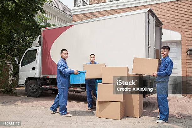 Movers Unloading A Moving Van Many Stacked Cardboard Boxes Stock Photo - Download Image Now