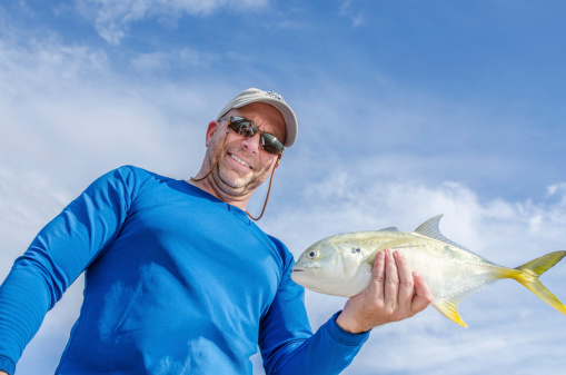 Fisherman with a Jack Crevalle in hand to be released