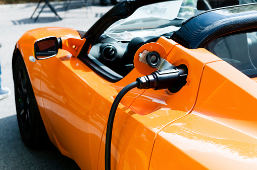 Copenhagen, Denmark  - August 6, 2011: Close up of a Tesla Roadster Sport which is charging. The electric car is produced by Tesla Motors in California, and the Tesla Roadster uses lithium-ion battery cells that make the car capable of traveling more than 200 miles (320 kilometers) on a single charge. 