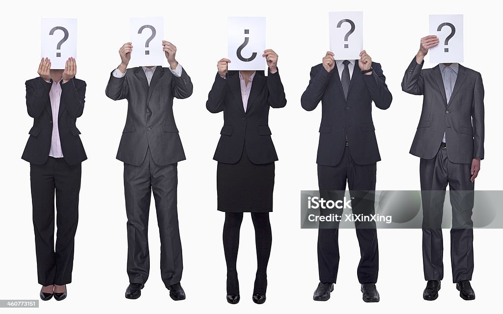 Business people holding up paper with question mark Five business people holding up paper with question mark, obscured face, studio shot Five People Stock Photo