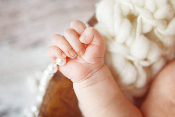 hands of a newborn baby with the nails, holding his mothers hand