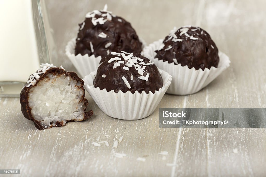 Coconut milk rice truffles with shredded coconuts Three and a halved coconut milk rice with bittersweet chocolate covered truffles on wood Cacao Fruit Stock Photo