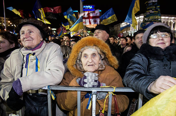 Kievv, Ukraine - December 5, 2013:old woman joins the anti government protest keeps on their protests in Maydan square.The protests were provoked when the Ukrainian president denied to sign an agreement with the EU. Mass protest are in progress despite a heavy police presence, sub-zero temperature and snow.