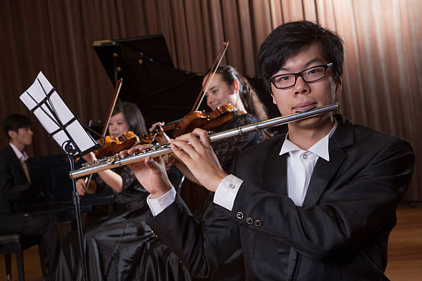 istock Flautist holding and playing the flute during a performance 460782813