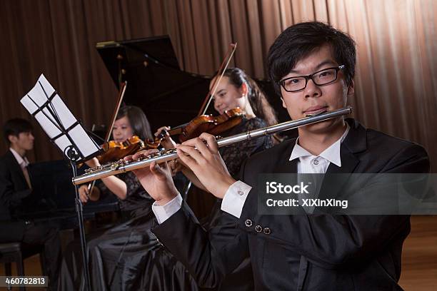 Flautist Holding And Playing The Flute During A Performance Stock Photo - Download Image Now