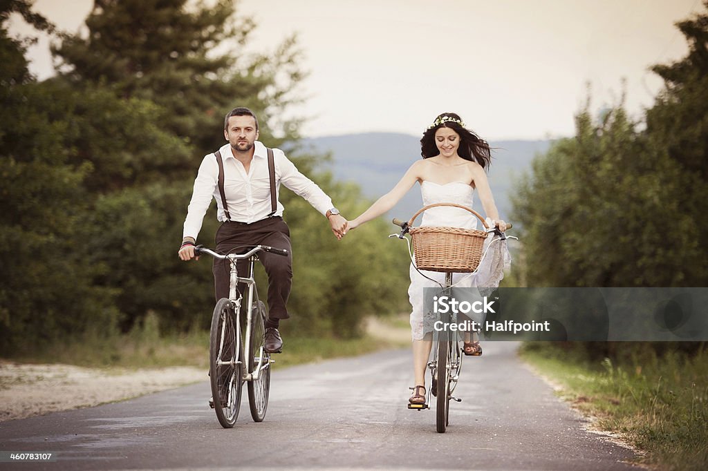 Bride and groom on the bikes Beautiful bride and groom riding on the bikes Cycling Stock Photo