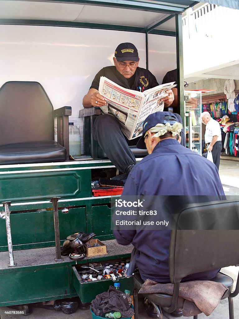 Peruvian man having shoes shined at Lima stall Lima, Peru - June 3, 2013: Peruvian man having his shoes shined by another at a Lima shoeshine stall Newspaper Stock Photo