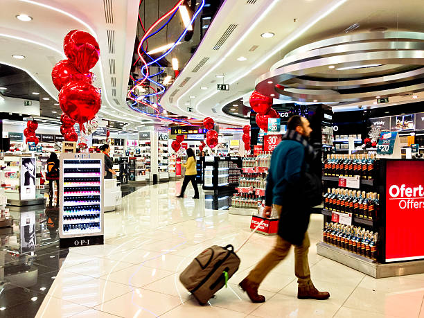 Duty Free Store at Madrid Airport, Barajas, Spain Madrid, Spain - December 28, 2013: Duty Free Perfume Store at Madrid Airport, Barajas, Spain. Man with luggage walking in shop. duty free stock pictures, royalty-free photos & images