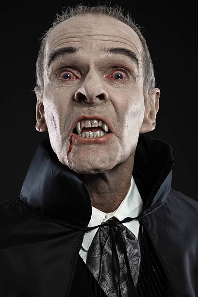 istock Dracula with black cape showing his scary teeth. Vamp fangs. 460813029