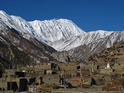 Old houses of Khangsar and snow capped Tilicho Peak, Nepal.