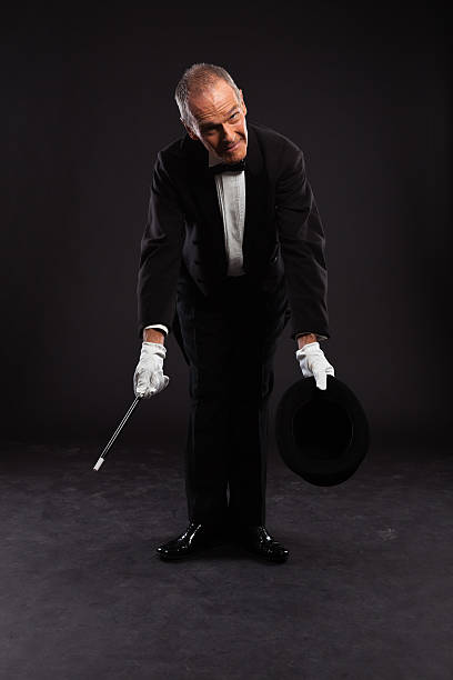 istock Magician with black suit and hat holding a magic stick. 460818925