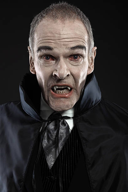 istock Dracula with black cape showing his scary teeth. Vamp fangs. 460818985