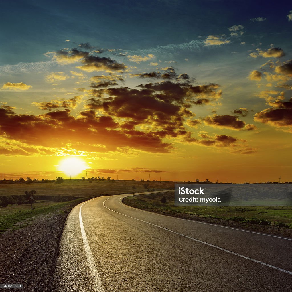 Naranja sol sobre la carretera asfaltada - Foto de stock de Aire libre libre de derechos