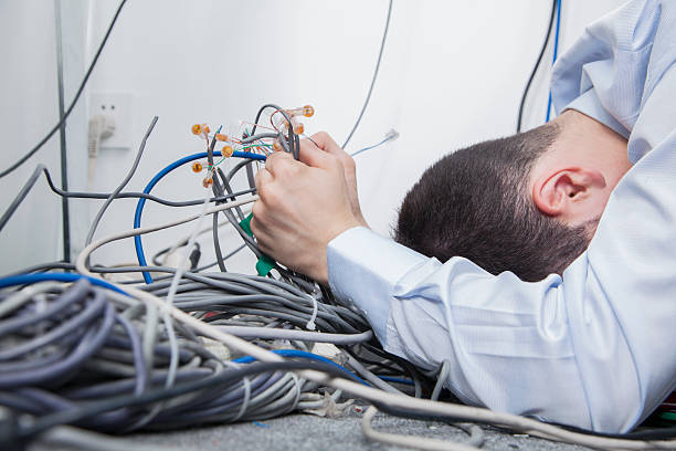 frustrierter mann versuchen, herauszufinden, computer-kabel - mit dem kopf gegen die wand rennen stock-fotos und bilder