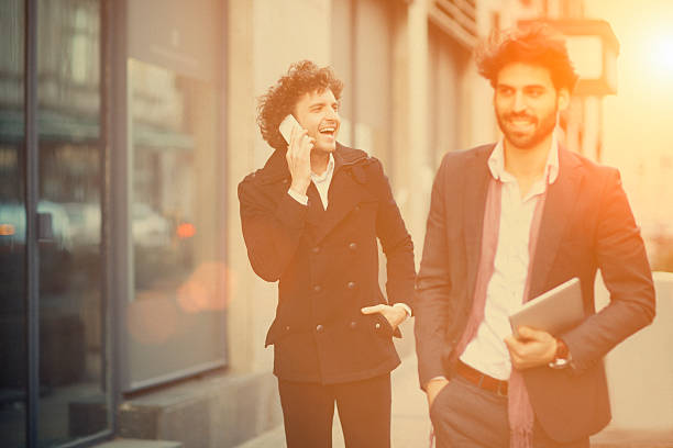 istock Two handsome young men walking on city street 460834743