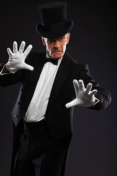 istock Magician making mysterious gestures. Wearing black suit and hat. 460841993