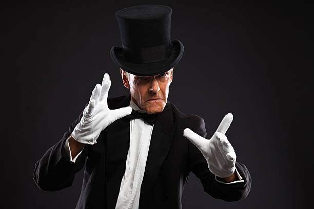 istock Magician making mysterious gestures. Wearing black suit and hat. 460842227