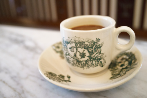 Empty white ceramic mug. Decorative flower pattern with one handle cup isolated on white background. Modern mug tea, coffee, or milk. Shiny bright color glazed vintage handmade for drinking water