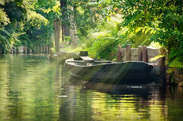 'Spreewald is a landscape in East Germany (near Cottbus). The river "Spree" floats here trough a deep forest and you can explore this landscape by boat. Everywhere are views to trees, boats, wooden houses and small holiday houses. Photo taken from boat.