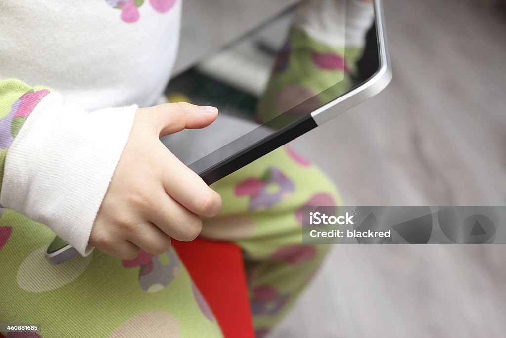 Child Holding a Touch Screen Tablet Close-up of a child holding a touch screen tablet. 12-17 Months Stock Photo
