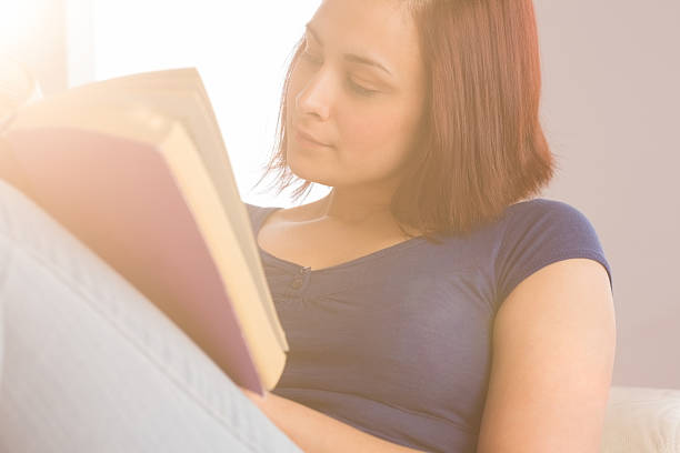 istock Peaceful young woman reading a book 460883567