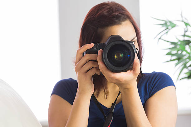 istock Cute young woman taking picture with her digital camera 460883663